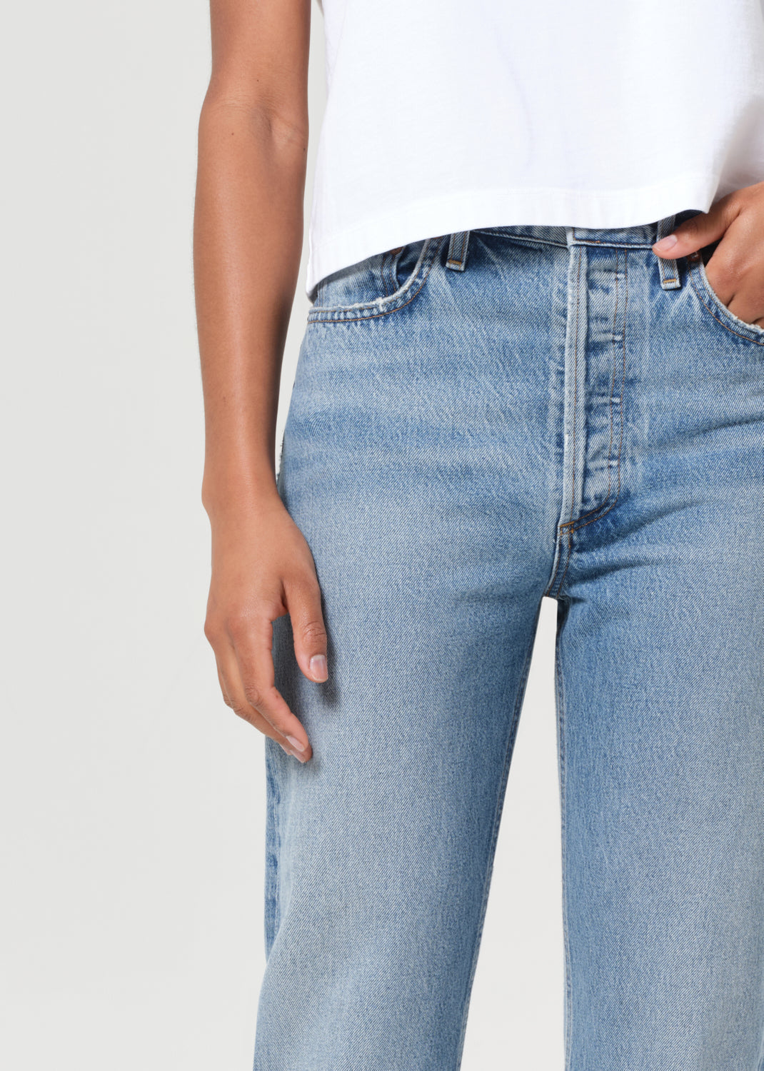 Light blue jeans worn by a person on a white background