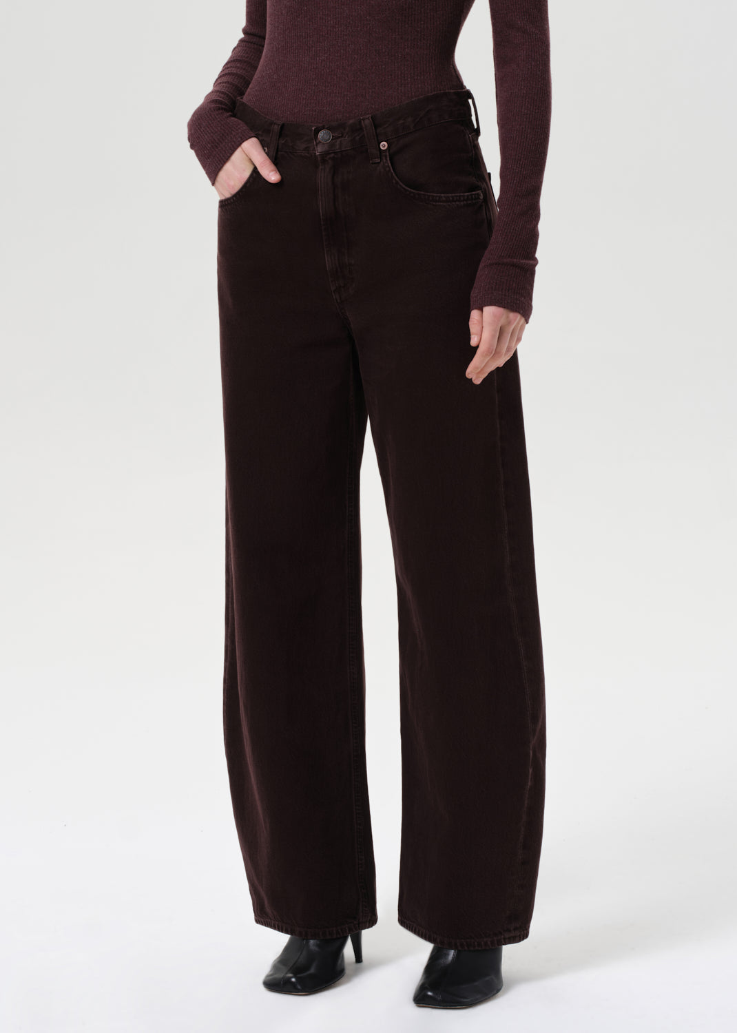 Person wearing dark brown wide-leg pants and a matching top on a white background