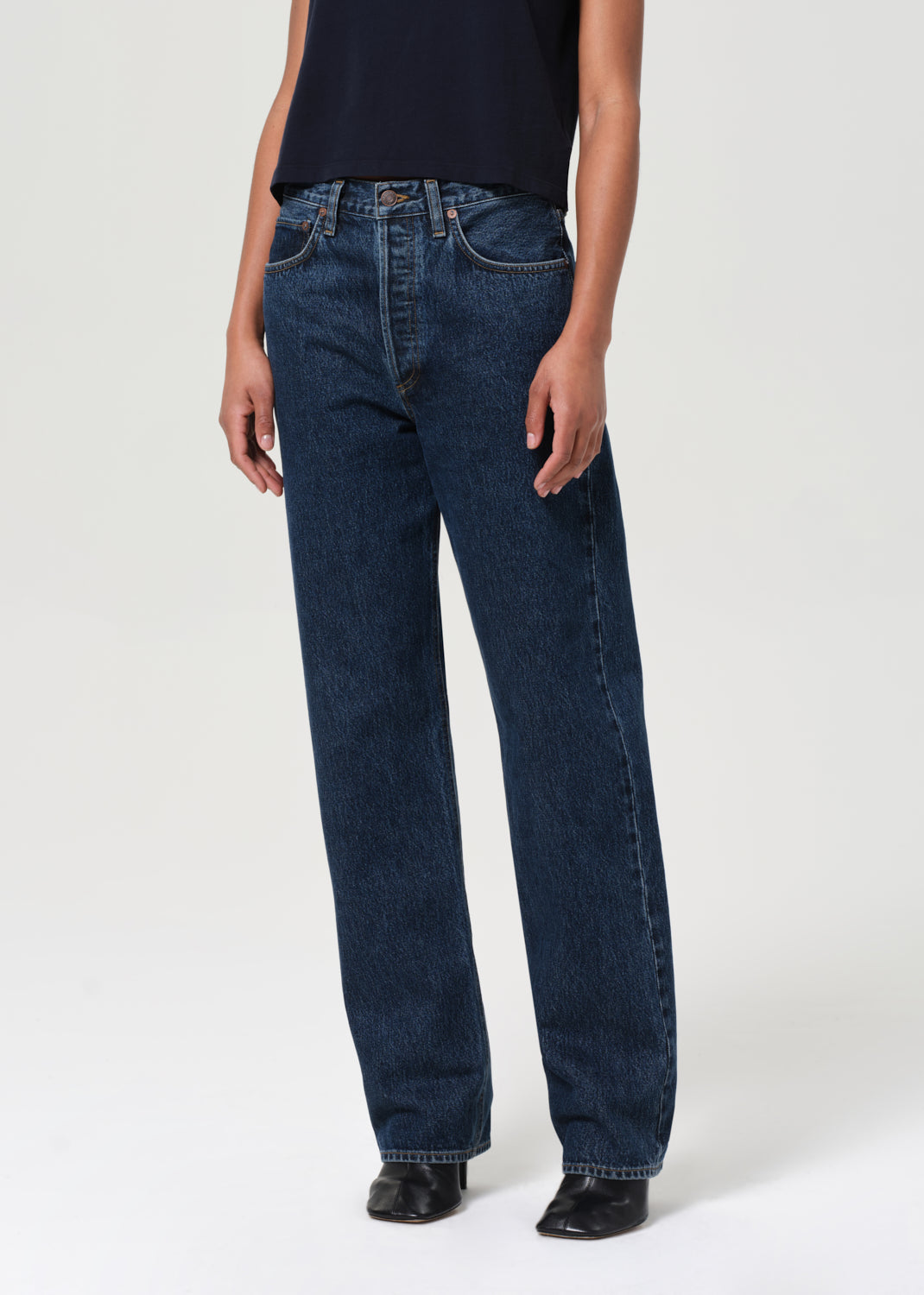 Person wearing dark blue jeans on a white background
