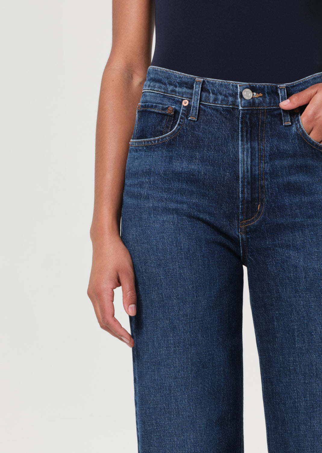 Blue jeans worn by a person on a light gray background