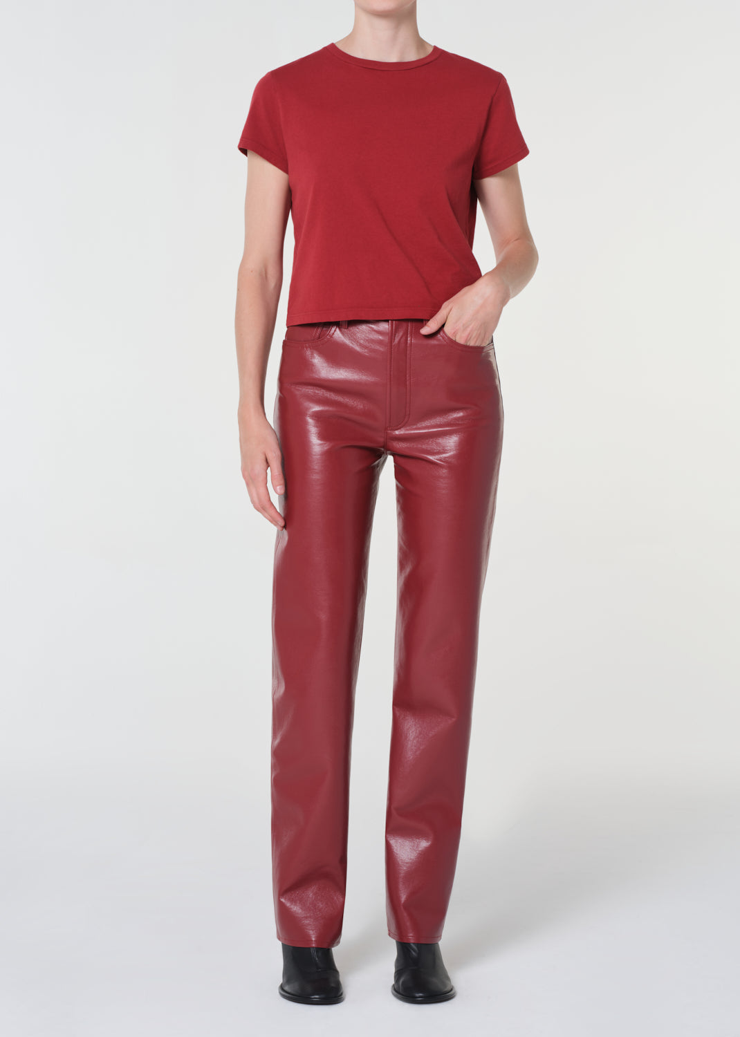 Person wearing a red t-shirt and red leather pants on a white background