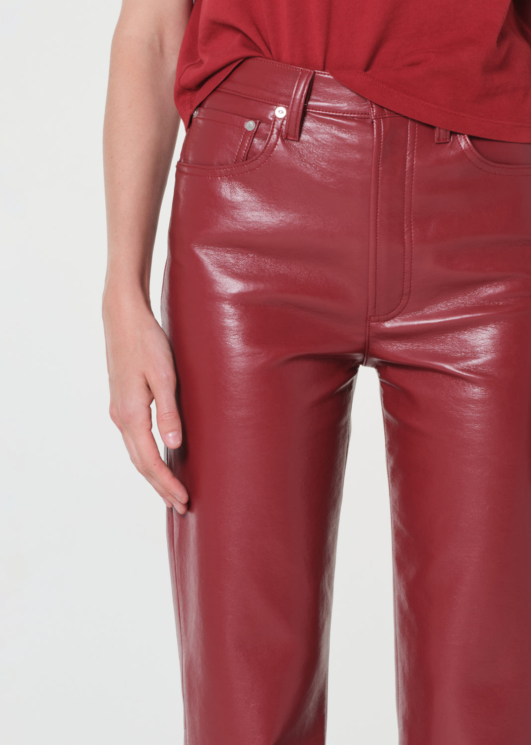 Red leather pants worn by a person on a white background
