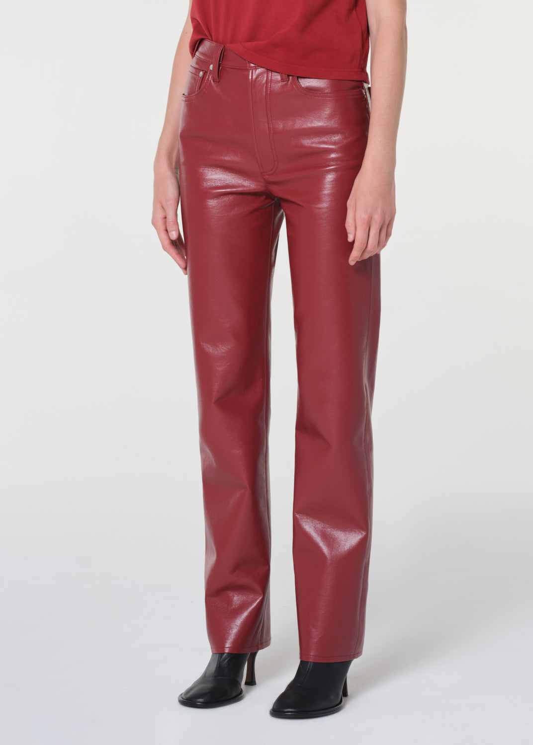 Person wearing red leather pants on a white background