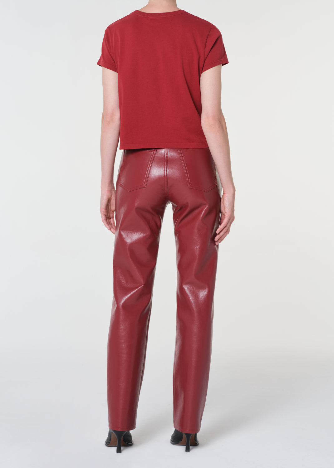 Person wearing a red t-shirt and shiny red pants on a white background