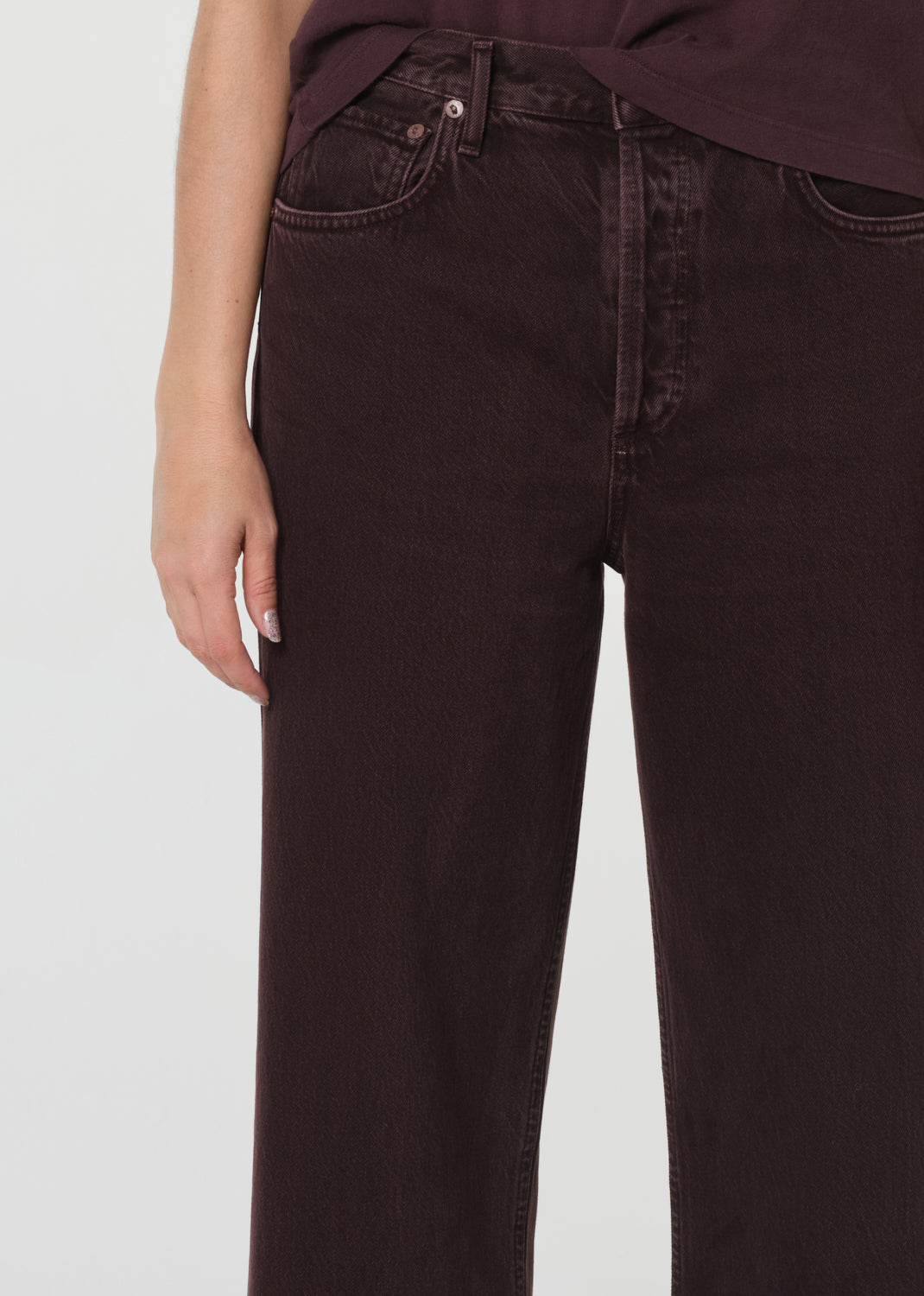 Brown jeans worn by a person on a light gray background