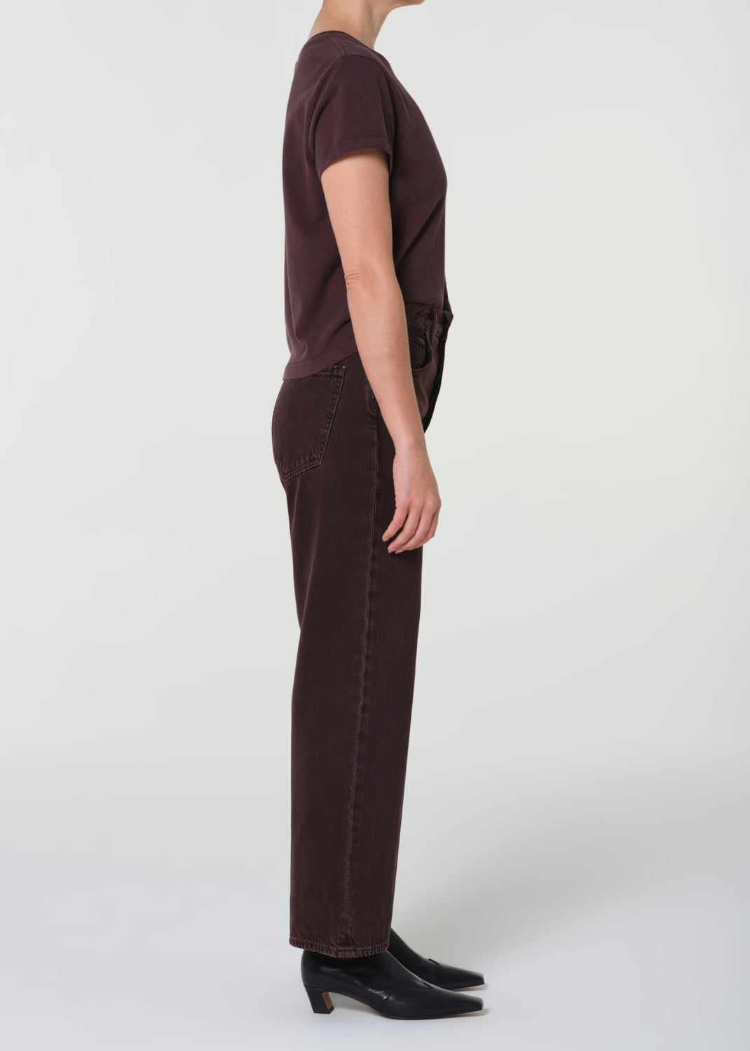 Person wearing a brown t-shirt and pants on a white background