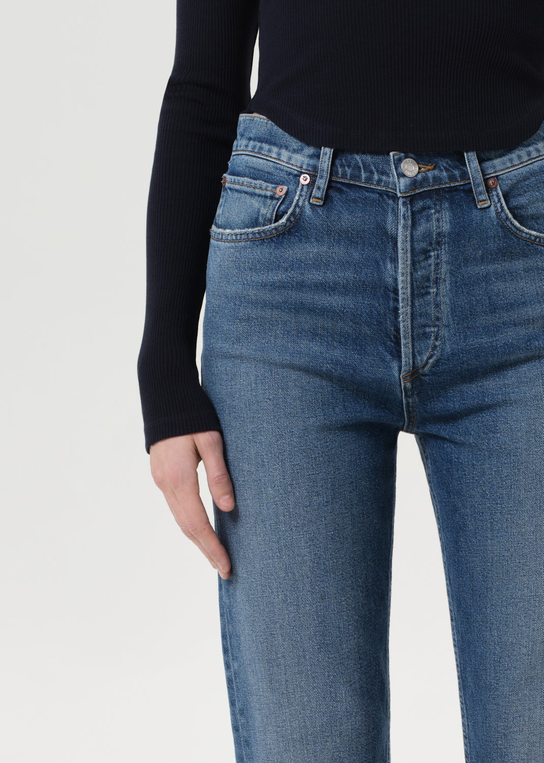 Blue jeans worn by a person on a light gray background