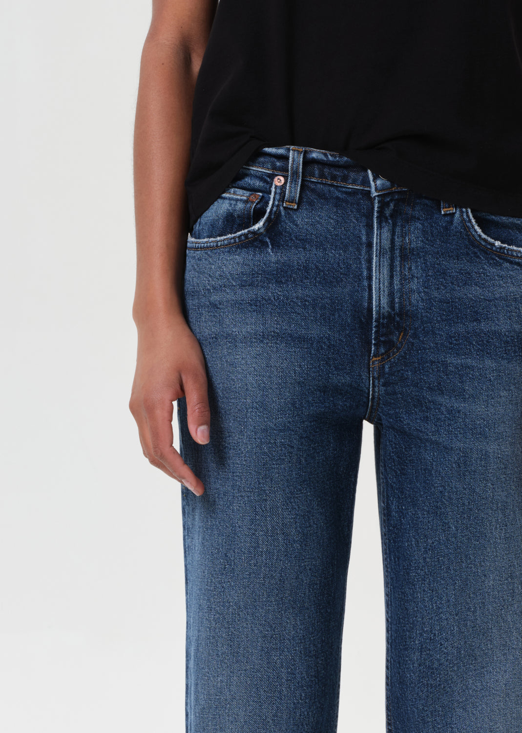 Close-up of blue jeans worn by a person on a light gray background