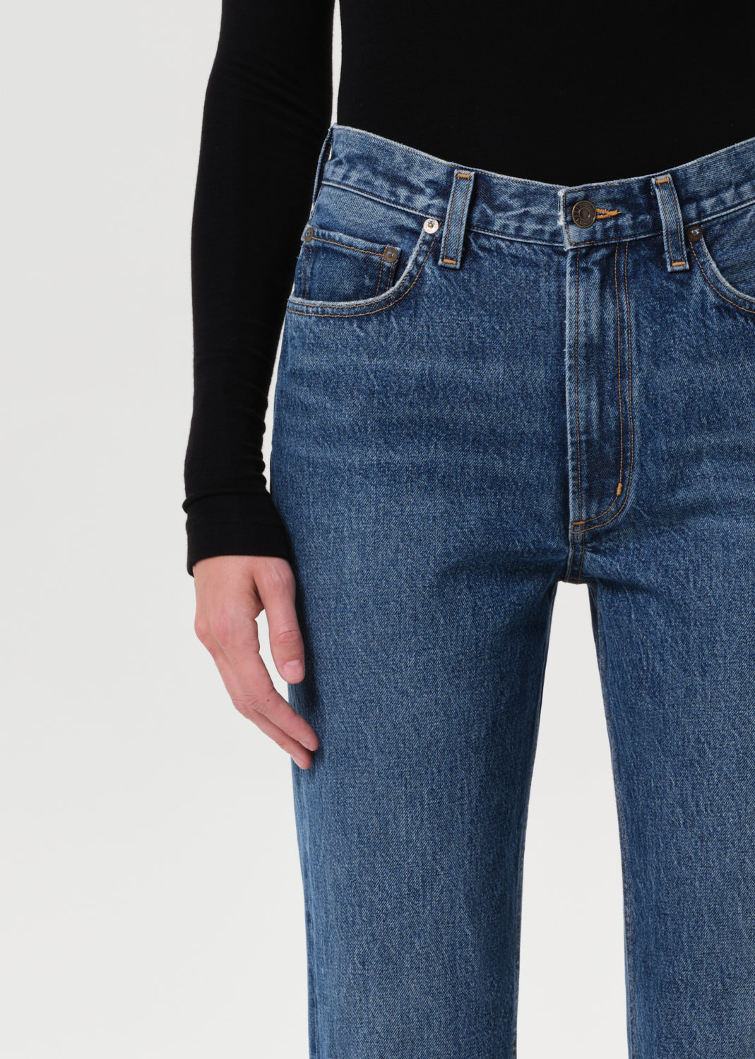 Person wearing blue jeans on a plain background