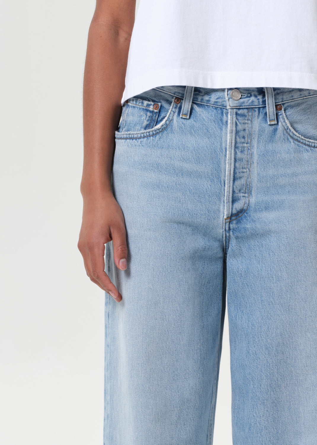 Light blue jeans worn by a person on a white background