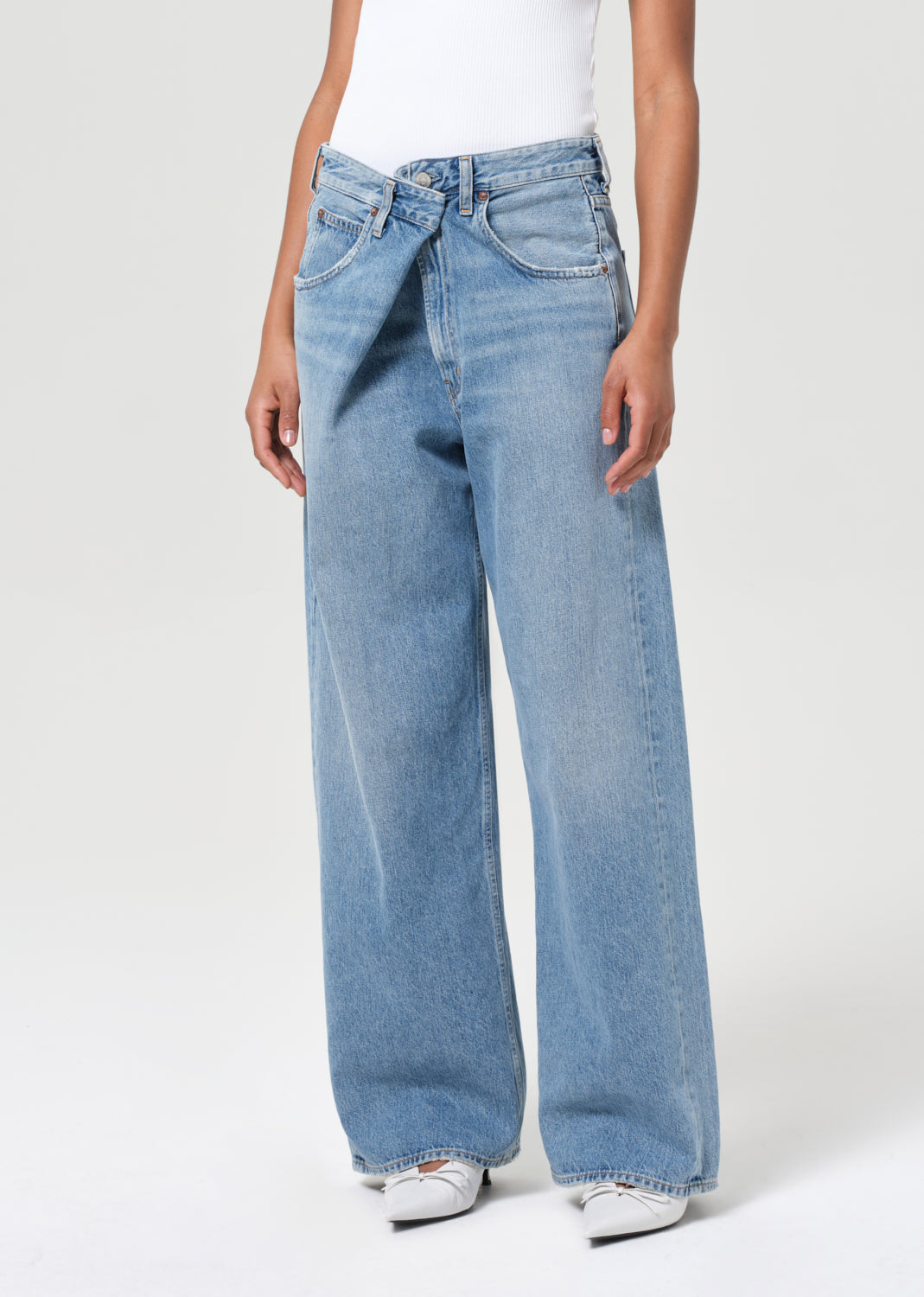 Person wearing light blue jeans on a white background