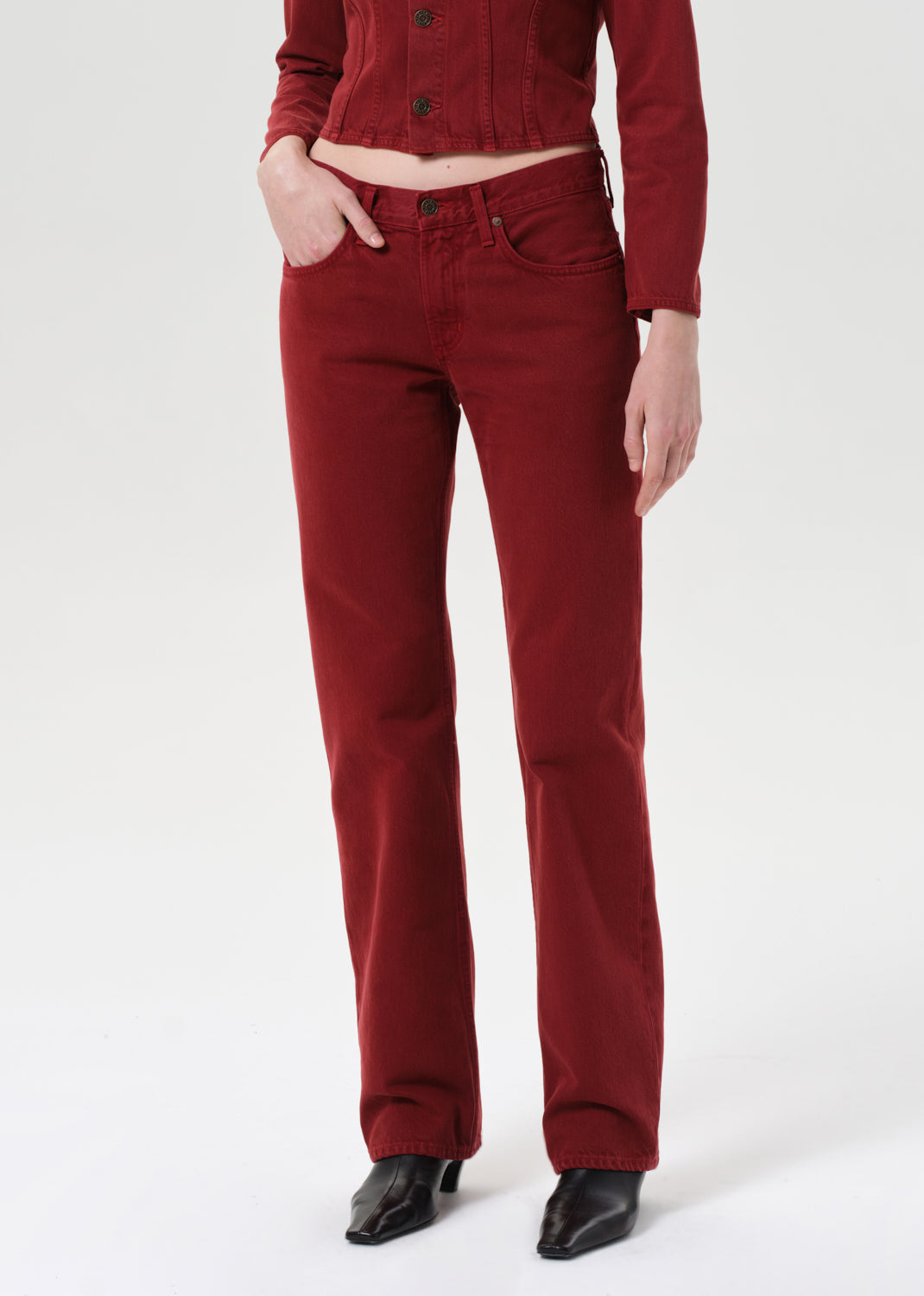 Person wearing red pants and a matching top on a white background