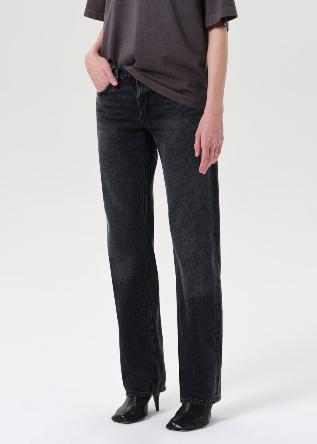 Person wearing black jeans and a dark shirt on a white background