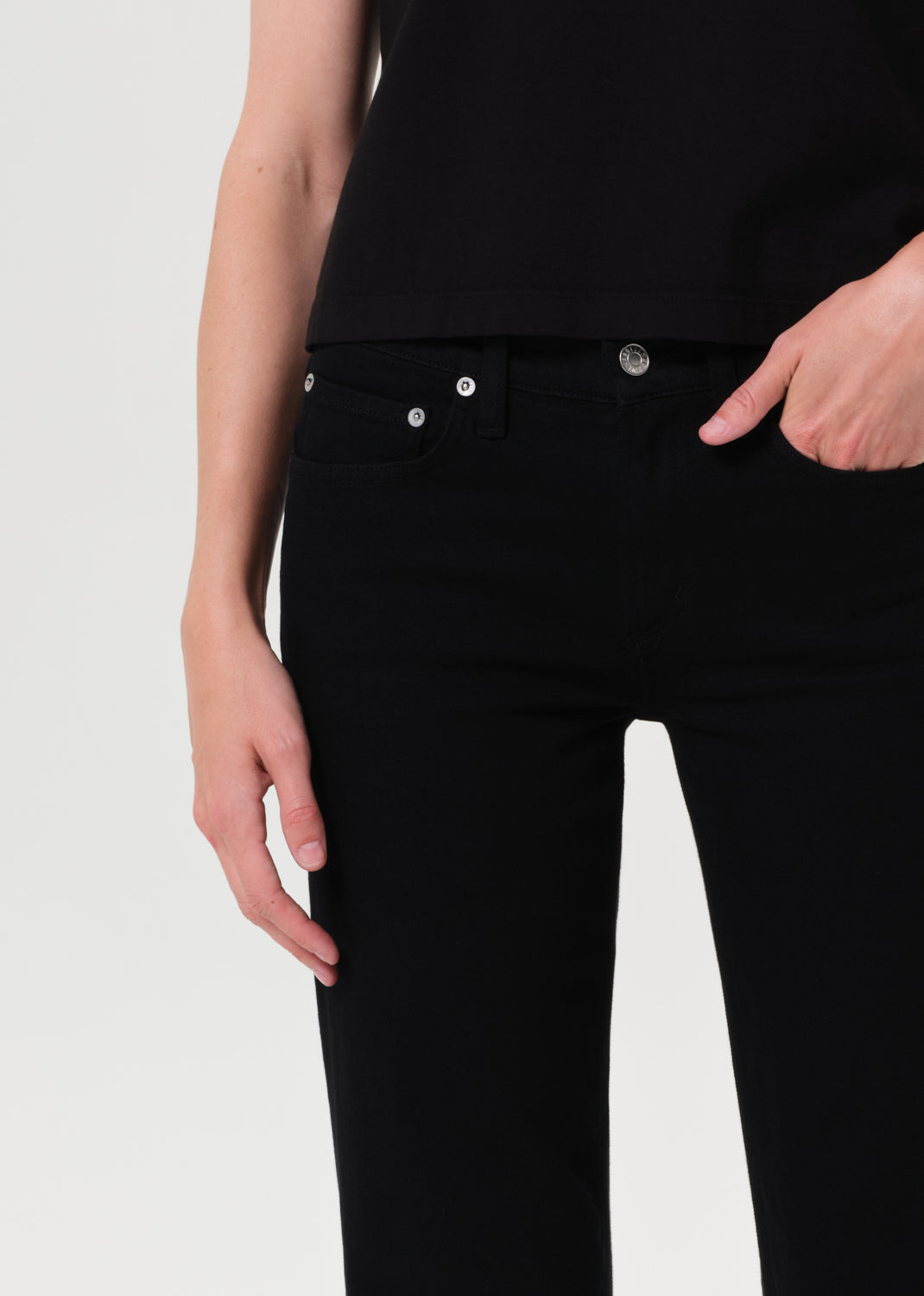 Person wearing black jeans on a white background
