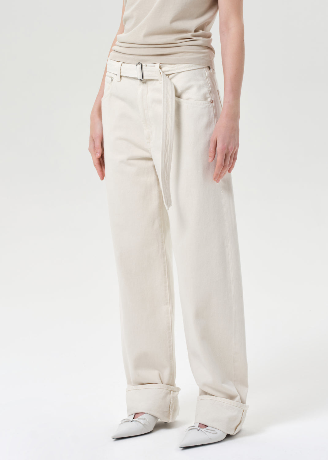 Person wearing beige pants and a light-colored top on a white background