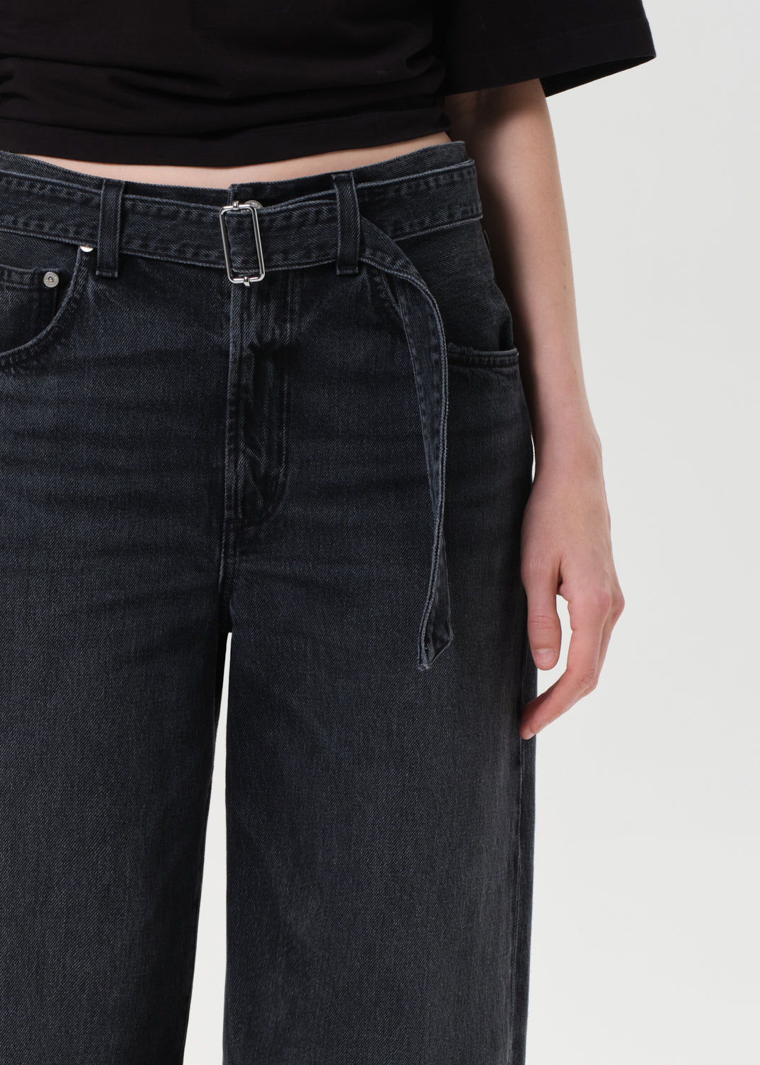 Black jeans worn by a person on a white background