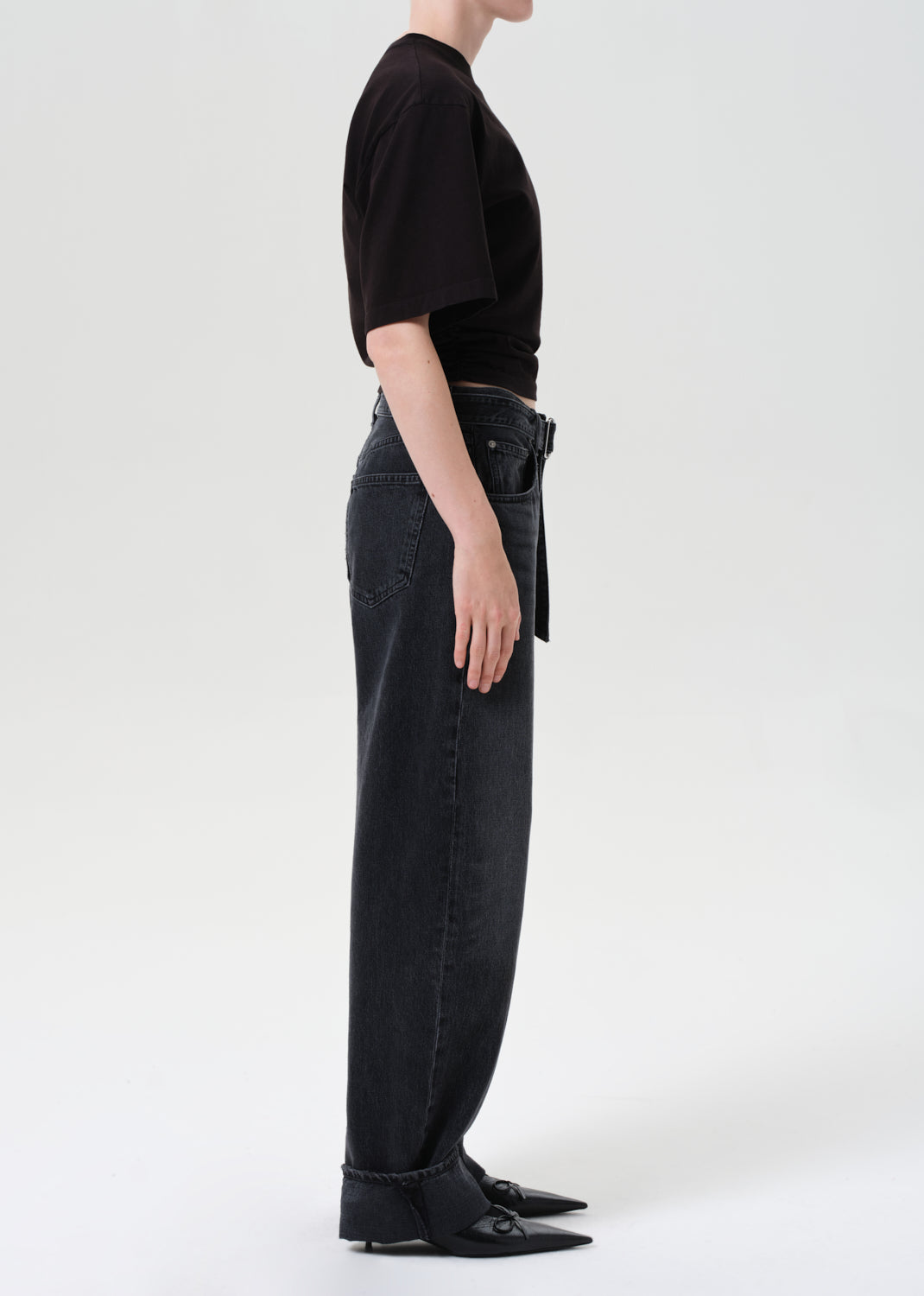 Person wearing black jeans and a black top on a white background