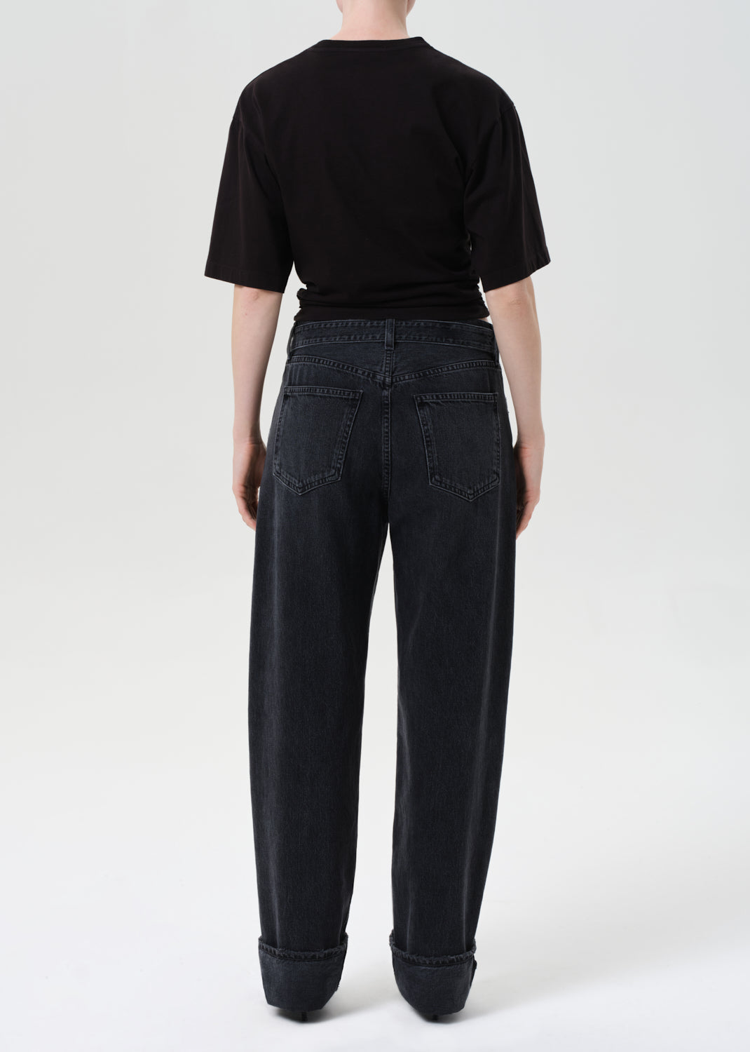 Person wearing black jeans and a black t-shirt on a white background