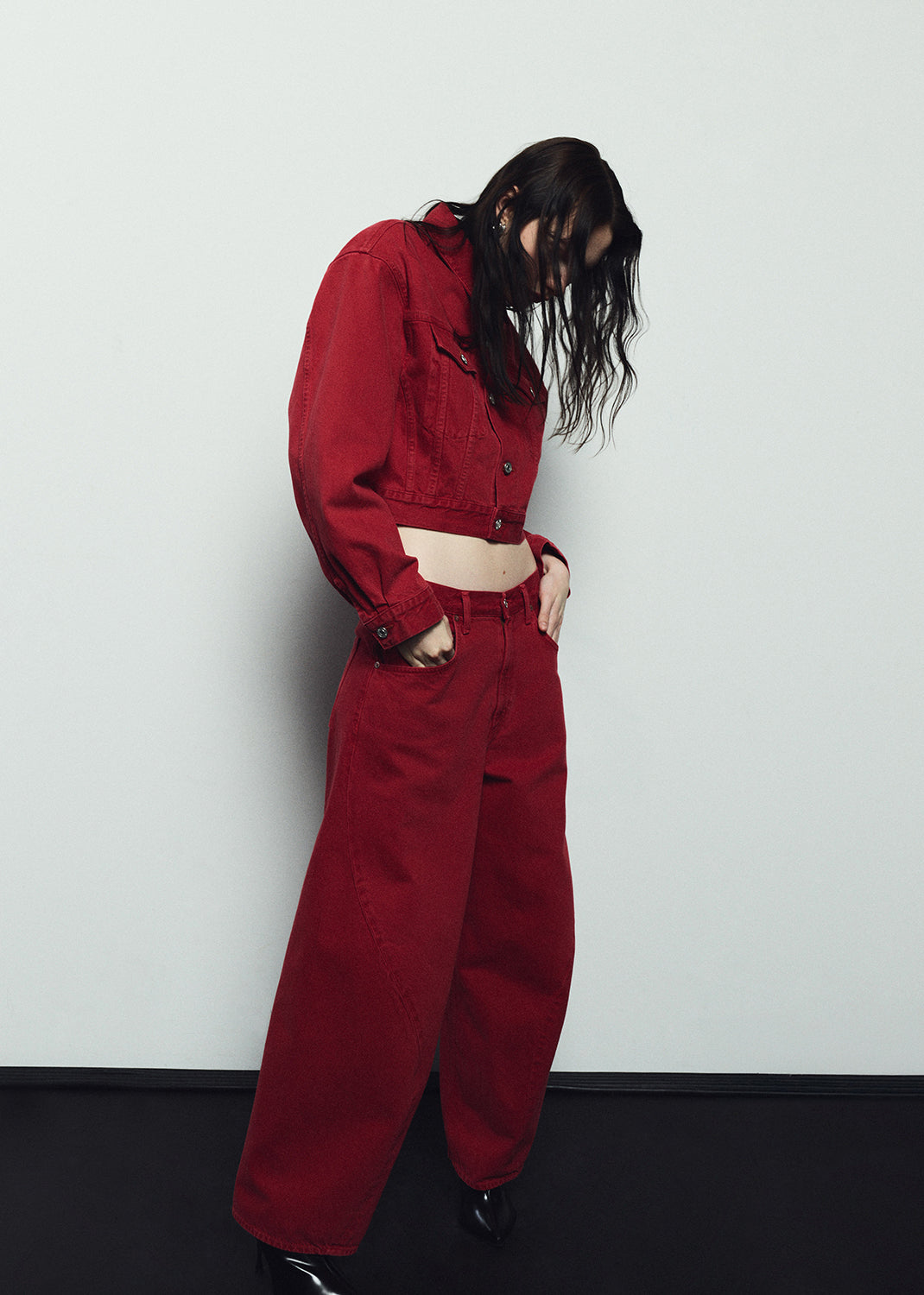 Person wearing a red outfit against a white wall