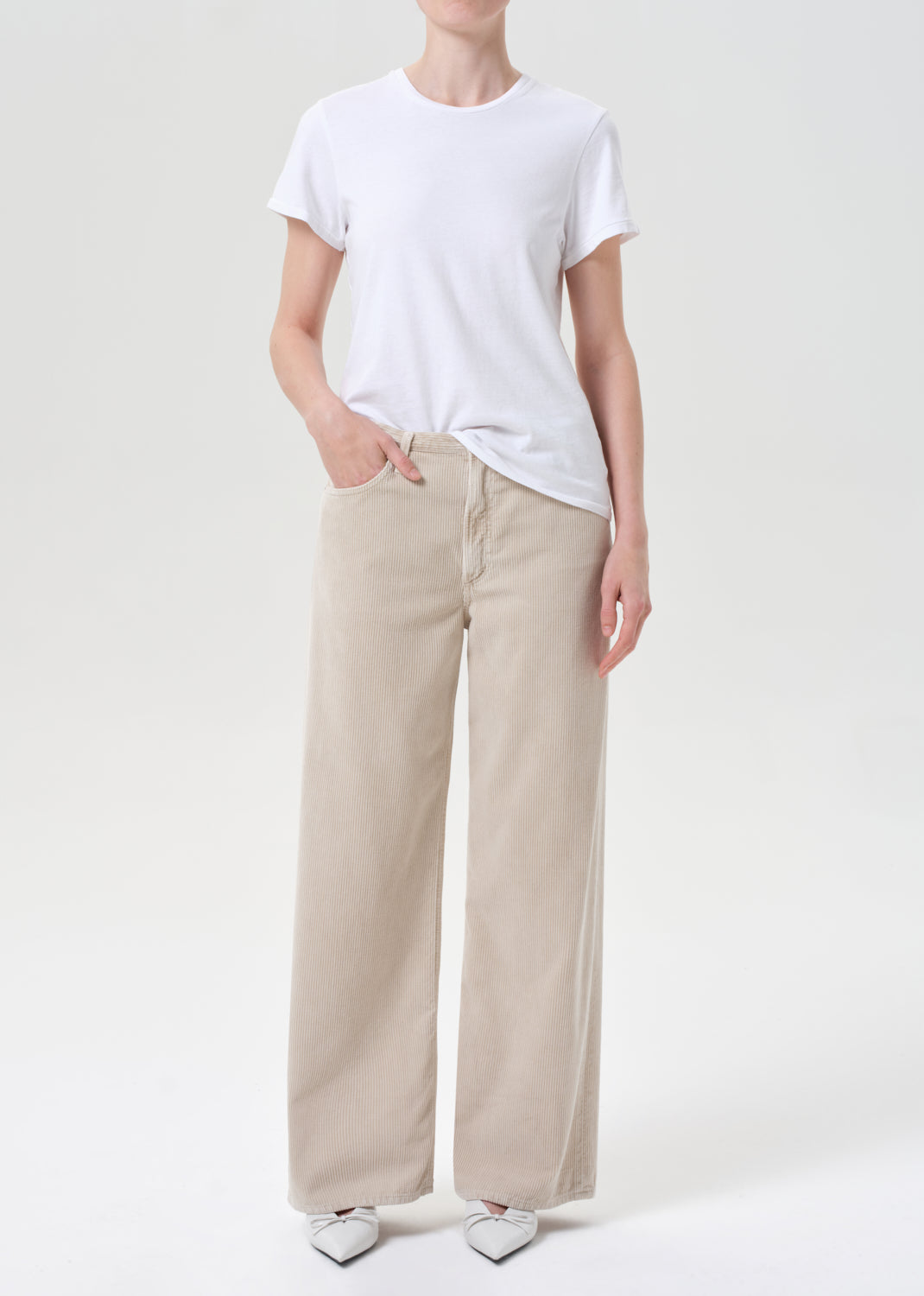 Person wearing a white t-shirt and beige pants on a white background