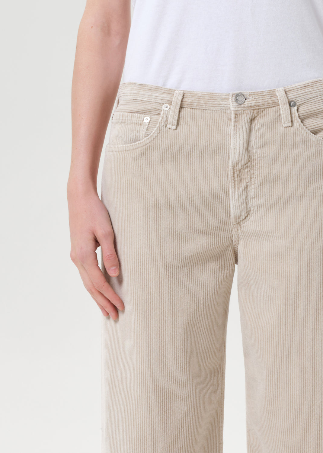 Beige striped pants worn by a person on a light gray background