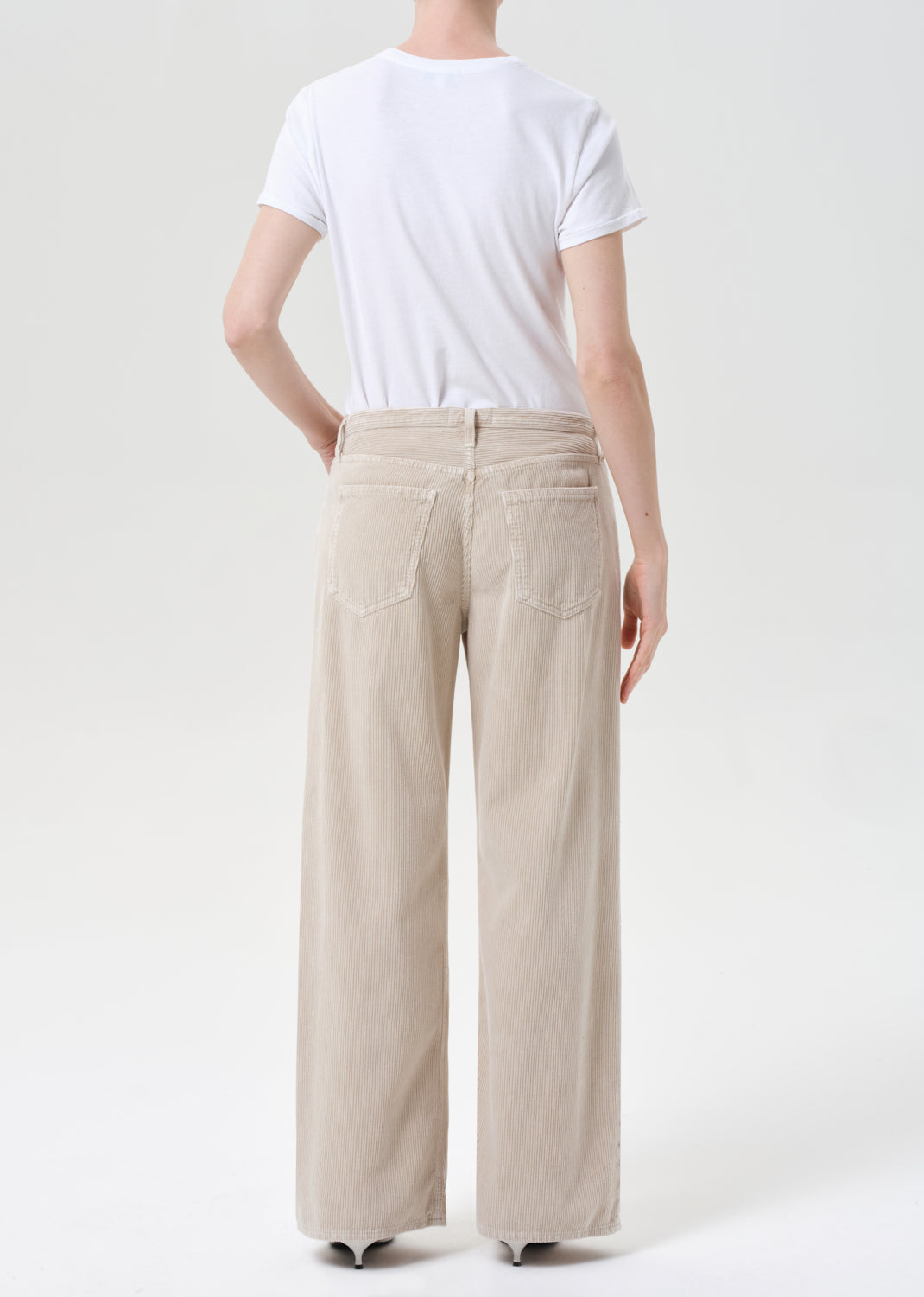 Person wearing beige wide-leg pants and a white t-shirt on a white background
