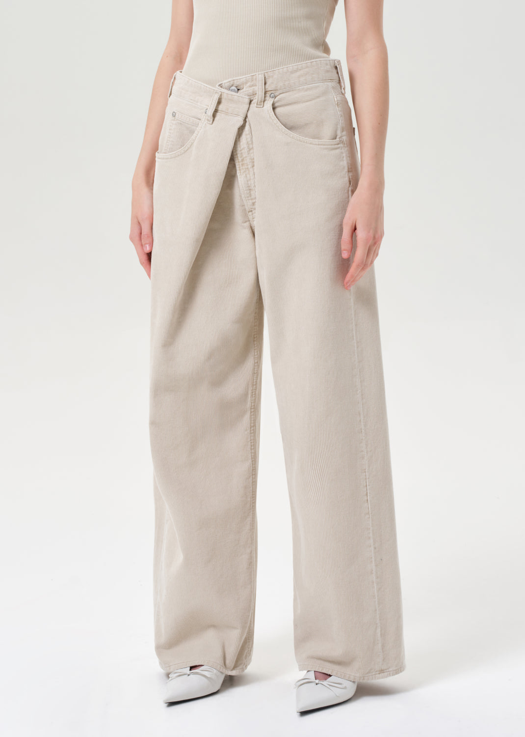 Beige wide-leg pants worn by a person on a white background