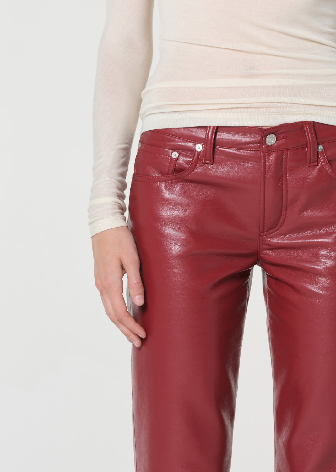 Red leather pants worn by a person on a white background