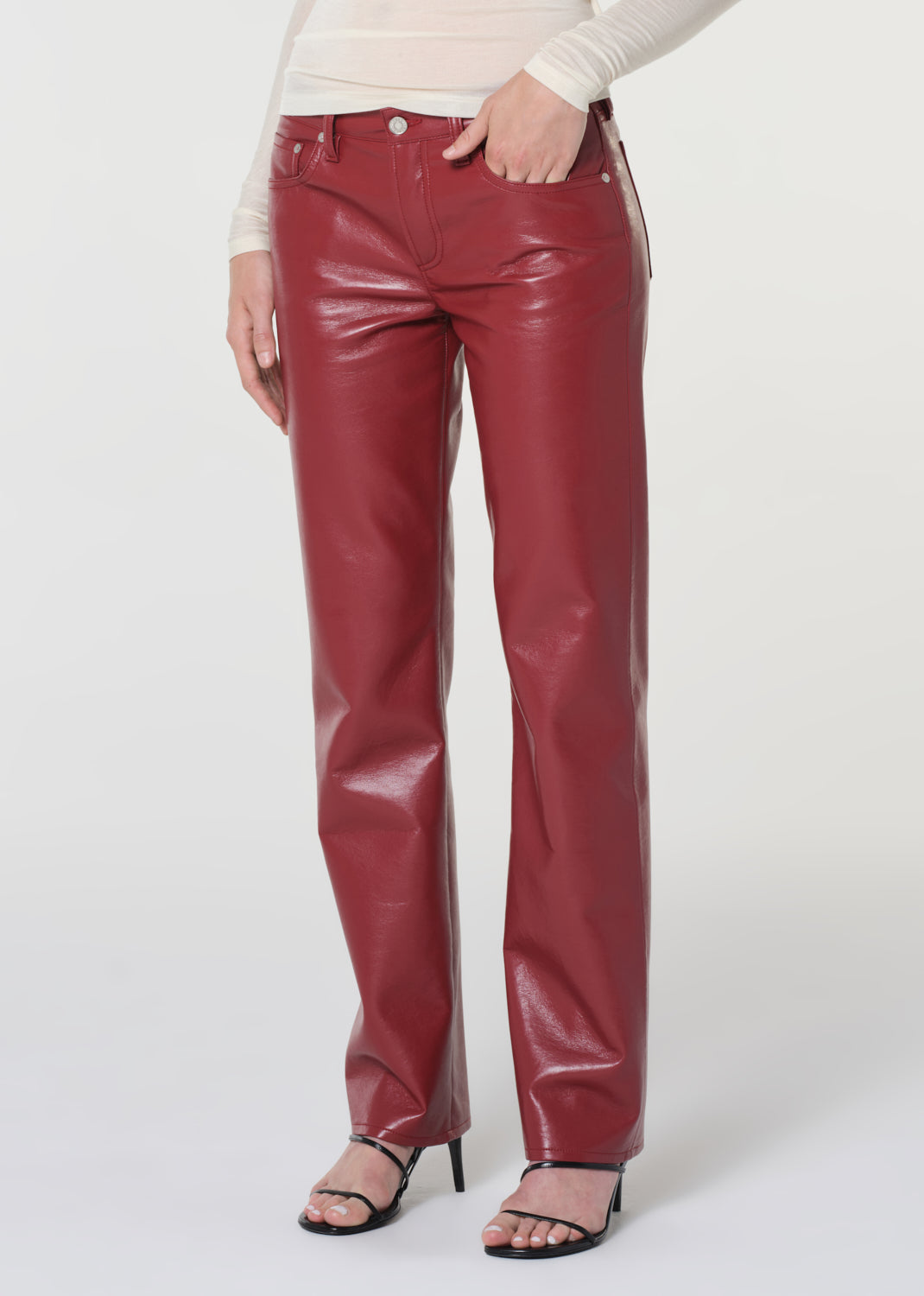 Red leather pants worn by a person on a white background