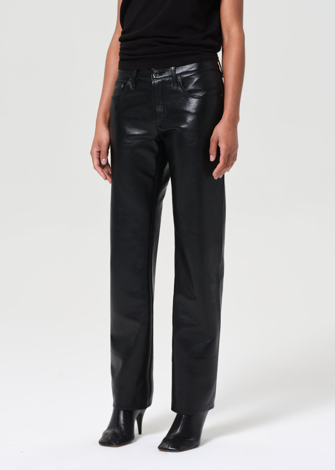 Person wearing black leather pants on a white background