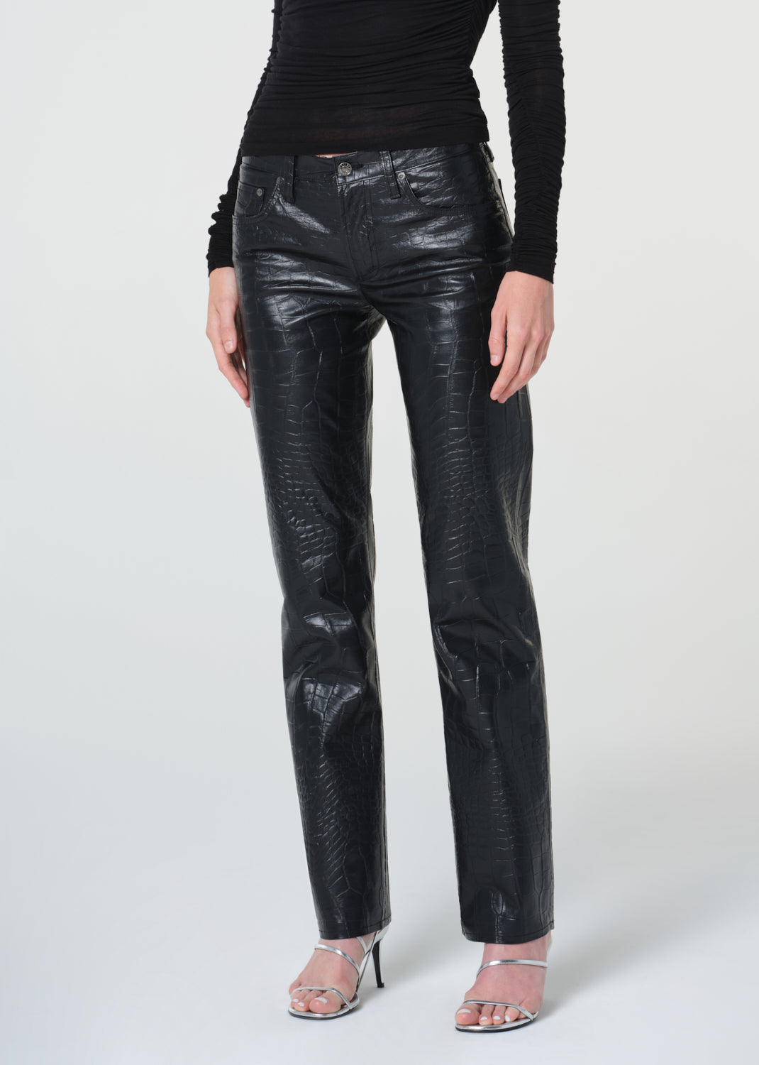 Person wearing black leather pants on a white background