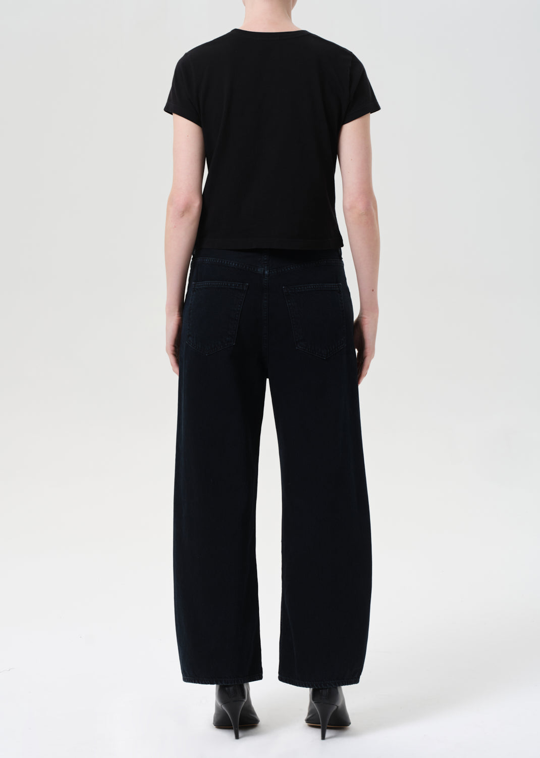 Person wearing a black t-shirt and black pants on a white background