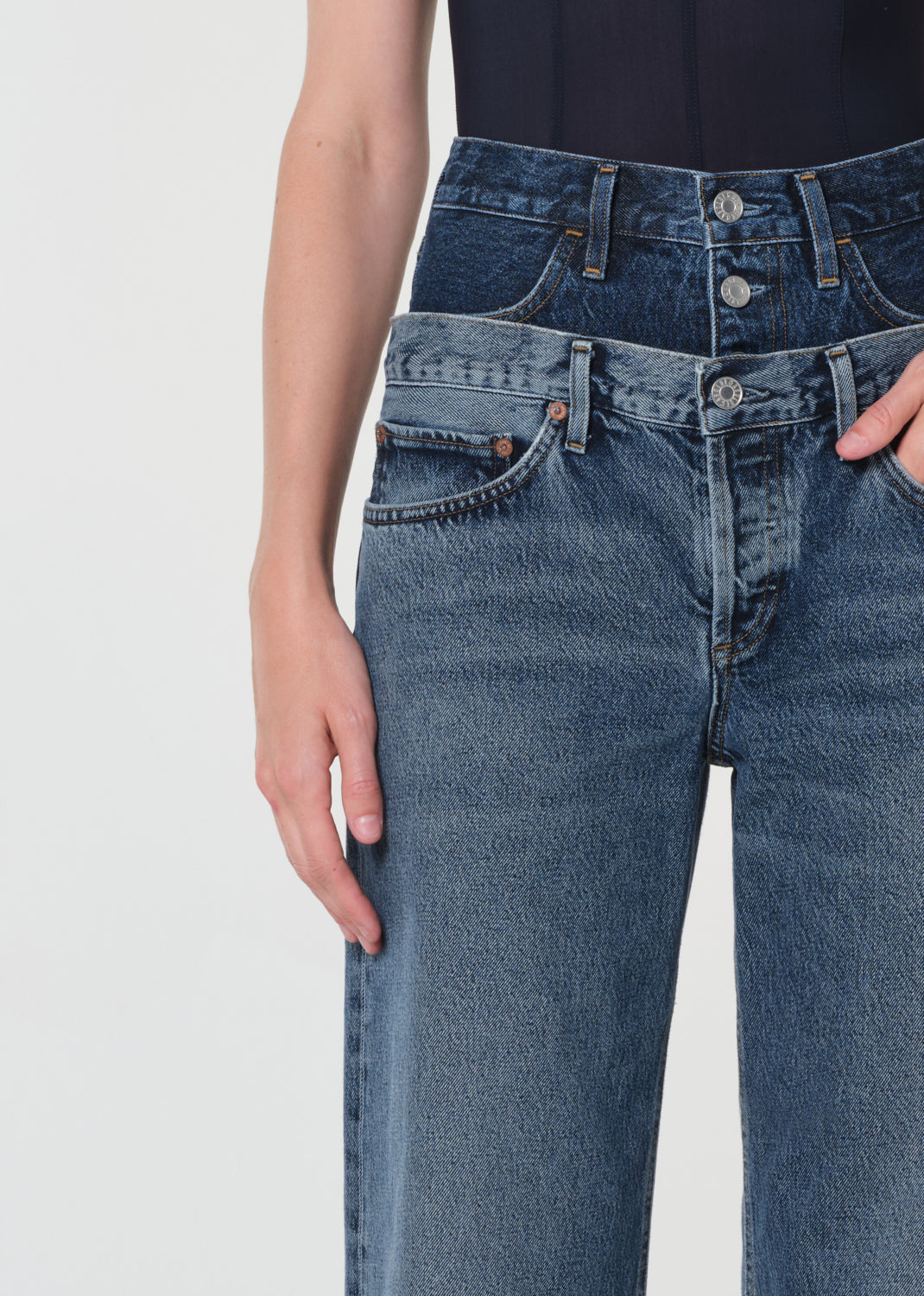 Blue jeans worn by a person on a light gray background