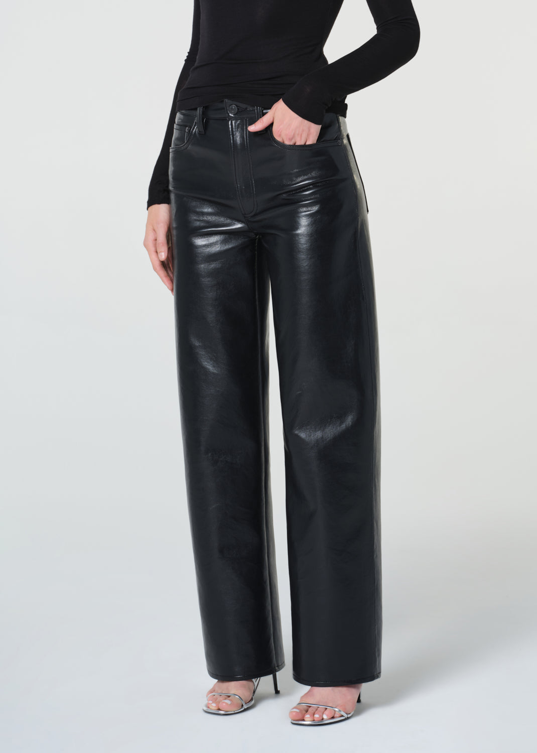 Person wearing black leather pants on a white background