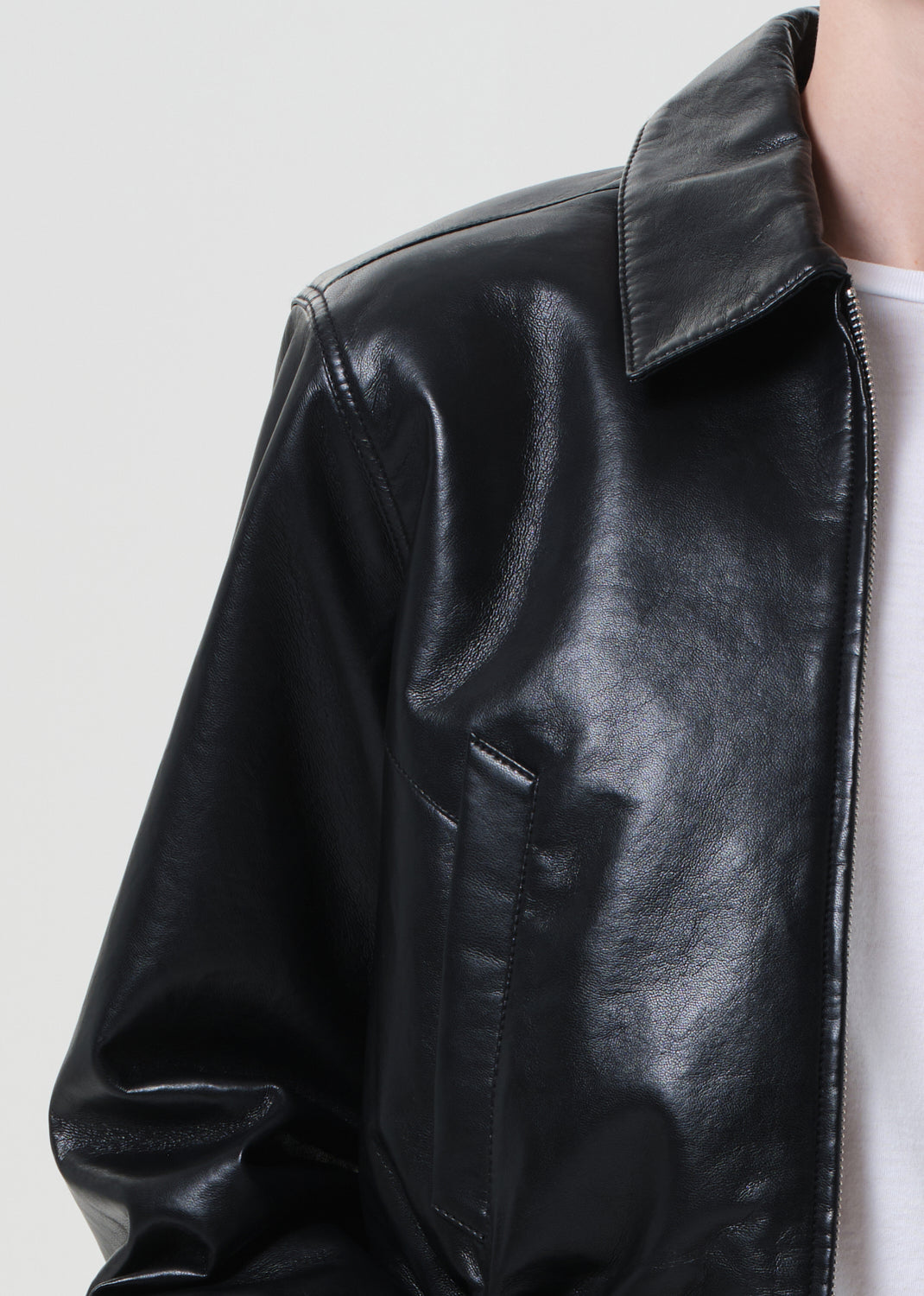 Close-up of a black leather jacket on a plain background