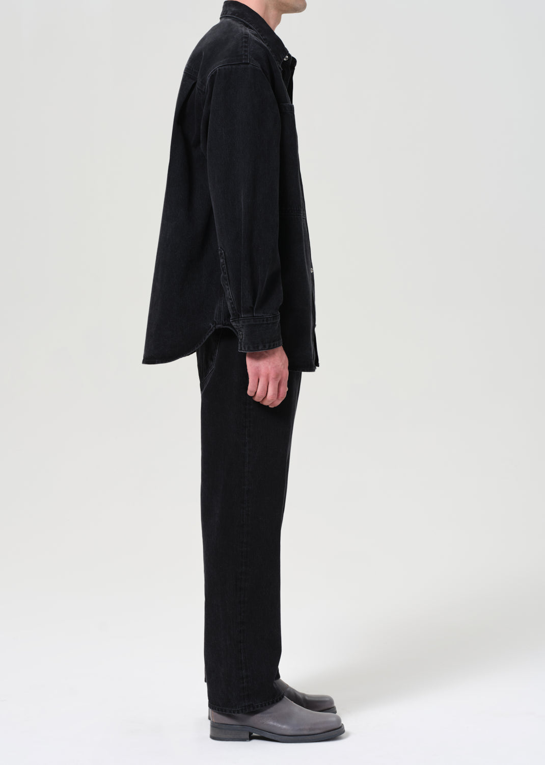 Person wearing a black outfit on a white background