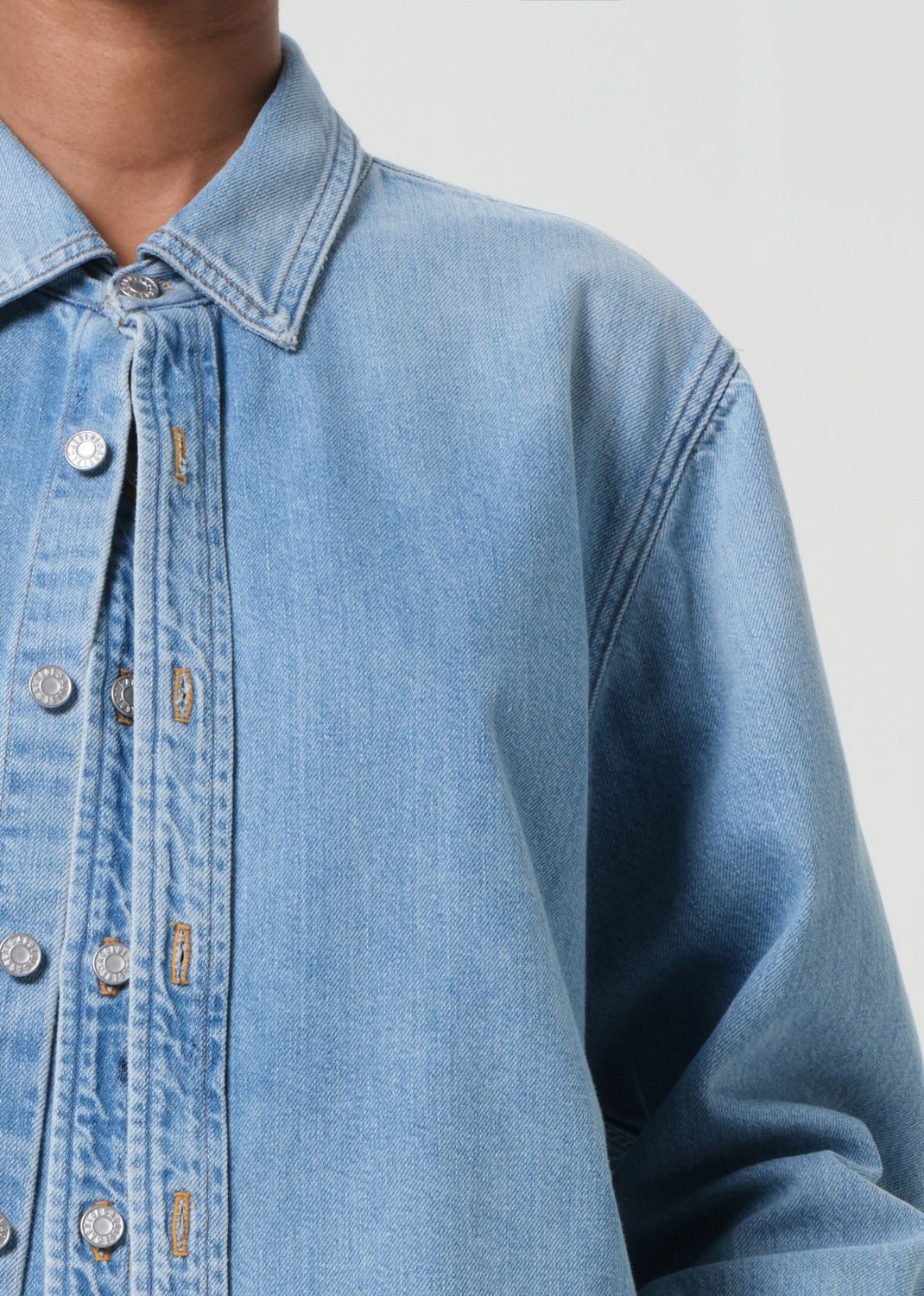 Close-up of a blue denim shirt with a plain background