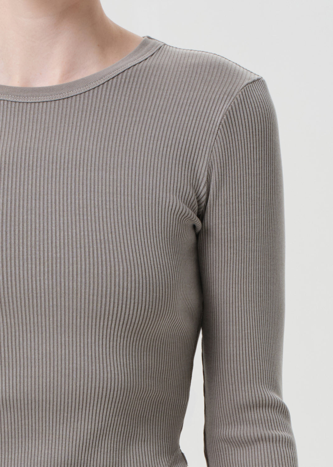 Close-up of a ribbed gray long-sleeve shirt on a plain background