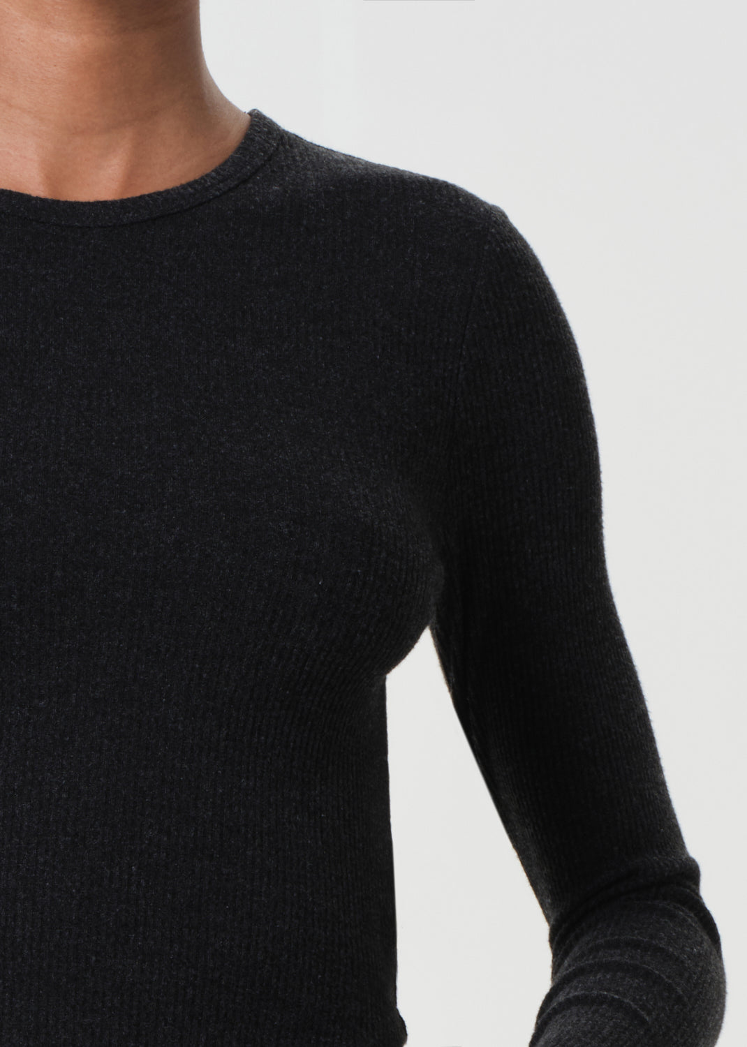 Black long-sleeve shirt worn by a person on a white background