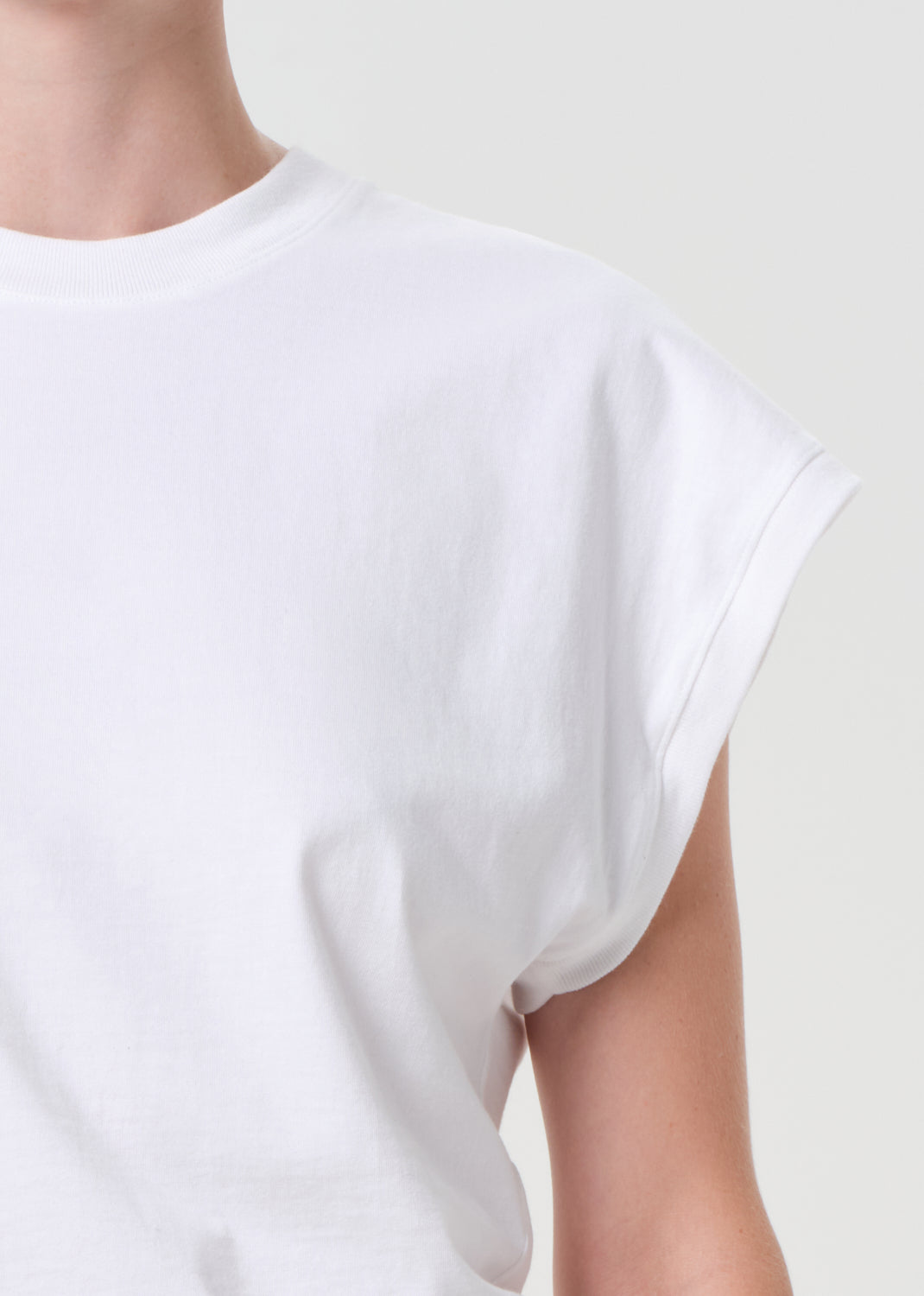 White t-shirt worn by a person on a plain background