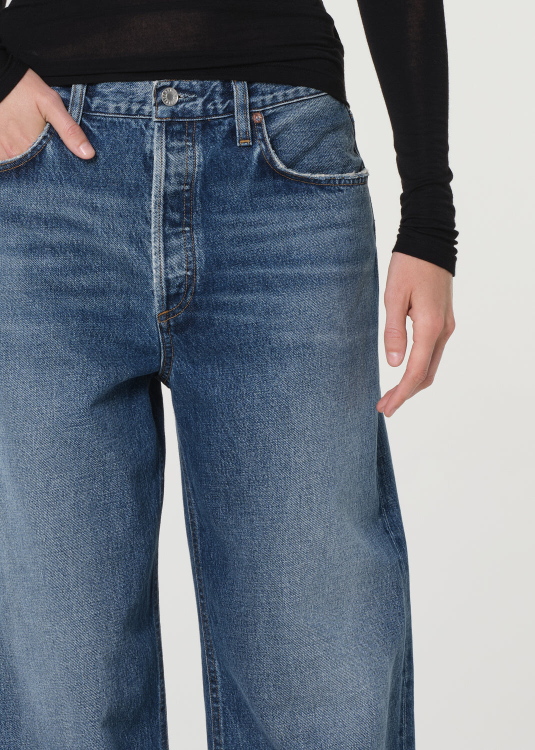 Blue jeans worn by a person on a white background