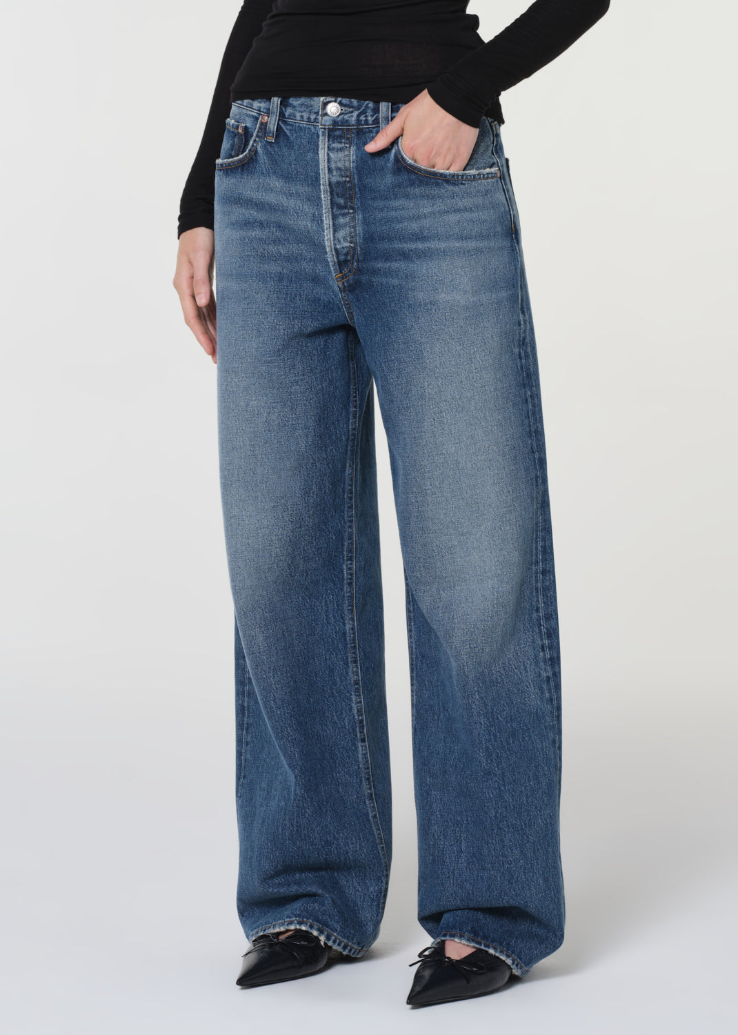 Person wearing blue wide-leg jeans on a white background