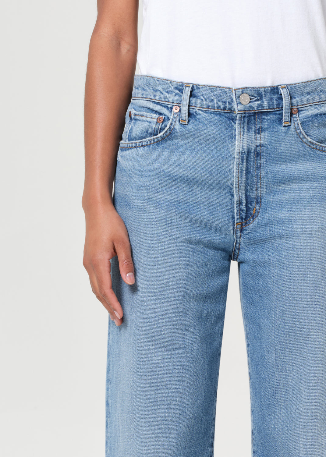 Light blue jeans worn by a person on a plain background