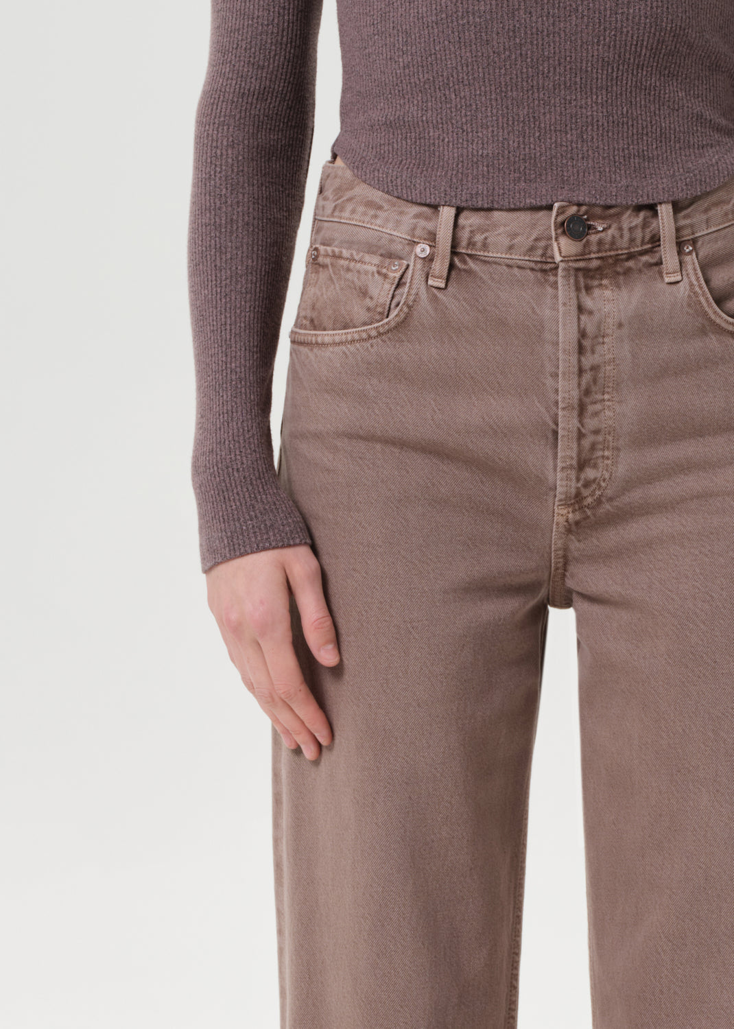 Brown pants worn by a person on a light gray background