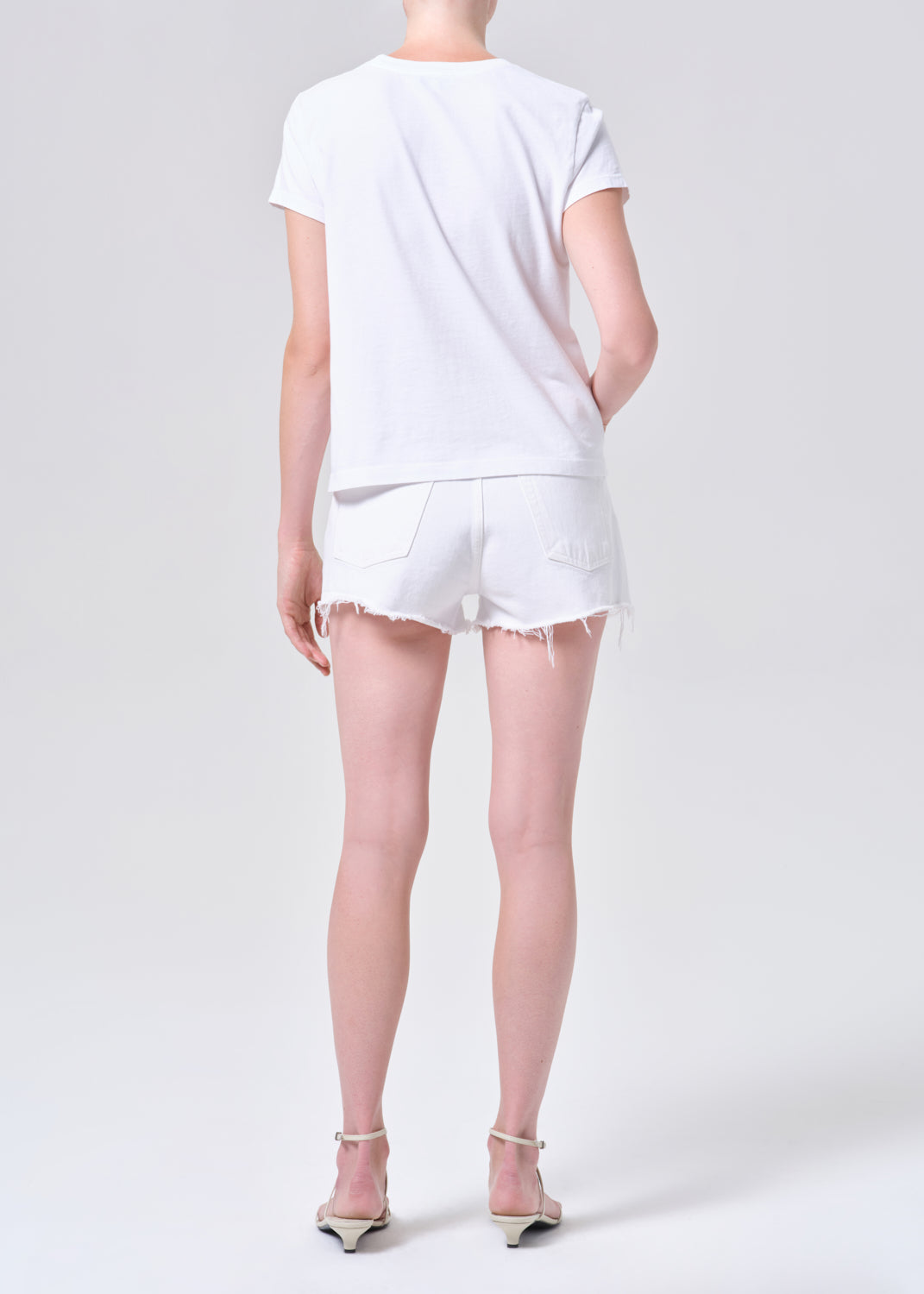Person wearing a white t-shirt and shorts on a plain background