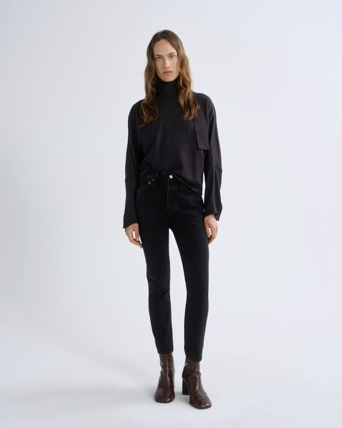 Woman wearing a black outfit with a plain white background