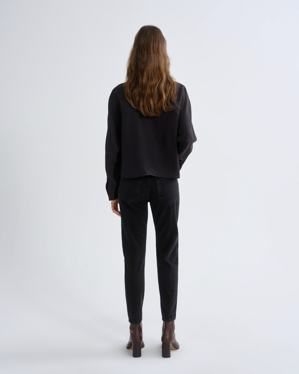 Person wearing a black outfit on a white background