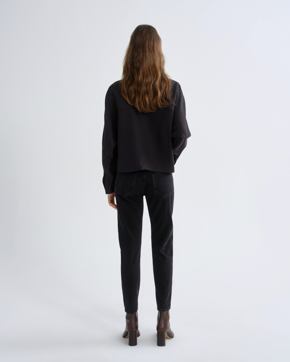 Person wearing a black outfit on a white background