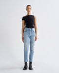 Person wearing a black top and light blue jeans on a white background