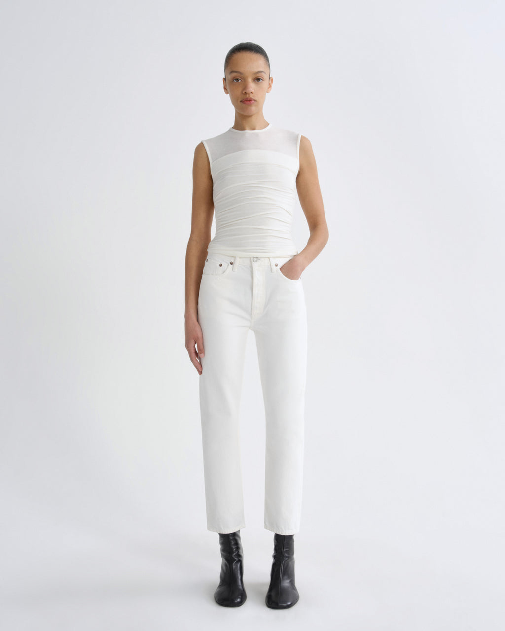 Person wearing a white sleeveless top and pants on a white background